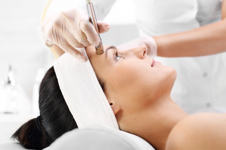 Frau empfängt eine kosmetische Behandlung mit Microneedling.
